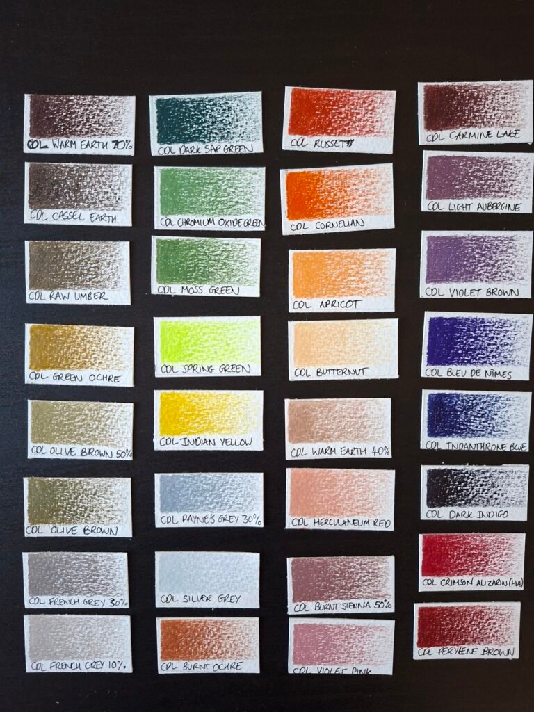 Swatches of cploured pencils on a black table.