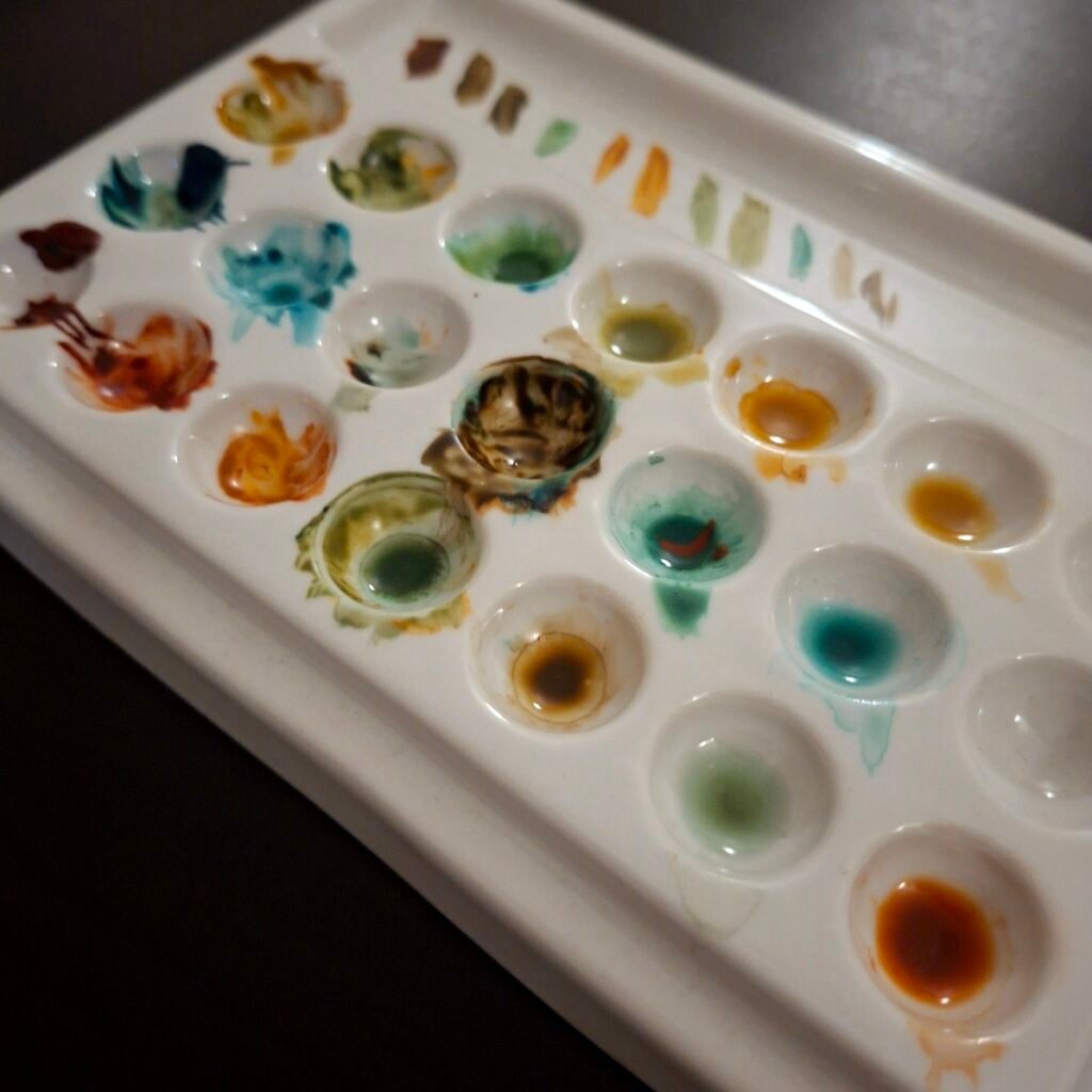 A ceramic palette with several small circular wells containing mixes of the paint from this selection.